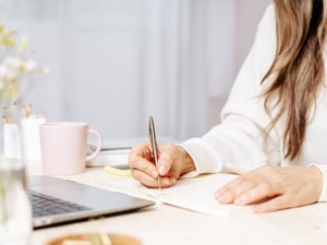 Frau schreibt ihre Schautanz Idee in ein Notizbuch